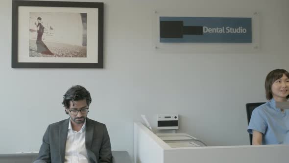 Patient and dental assistent asking for telephone number at front desk alt