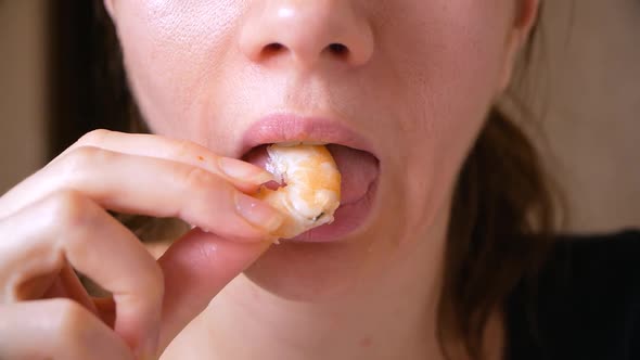 Closeup of Beautiful Young Woman Eats Boiled Shrimp. Mouth Chewing Shrimp alt