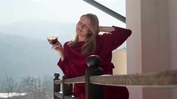 Young woman on balcony at chalet. alt
