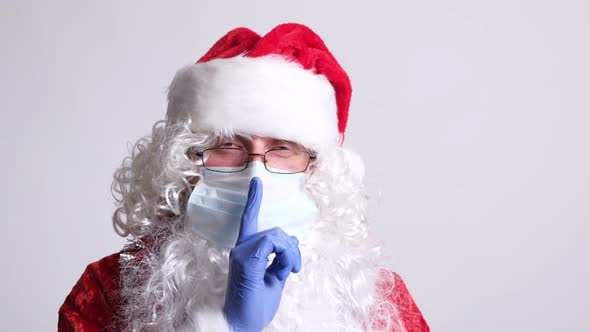 Santa Claus in Surgical Mask and Gloves Holding Finger Near Lips
