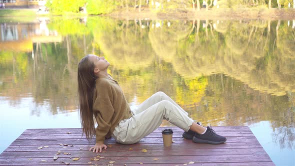 Fall Concept - Beautiful Girl in Autumn Park on the Lake