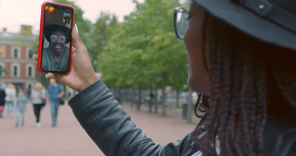 View Over Shoulder of African American Woman Smiling Happy Doing Video Call on Smartphone at City alt