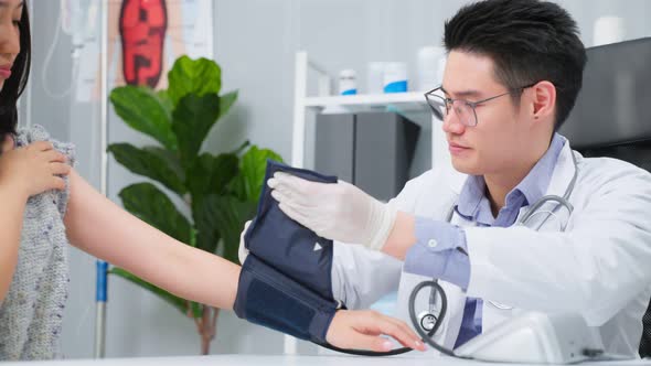Asian specialist male doctor use blood pressure gauge examine patient. alt