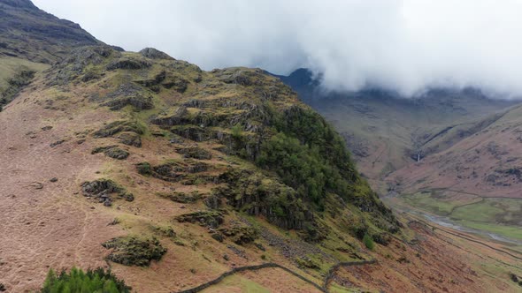 Aerial View Over Hills Towards Mountains