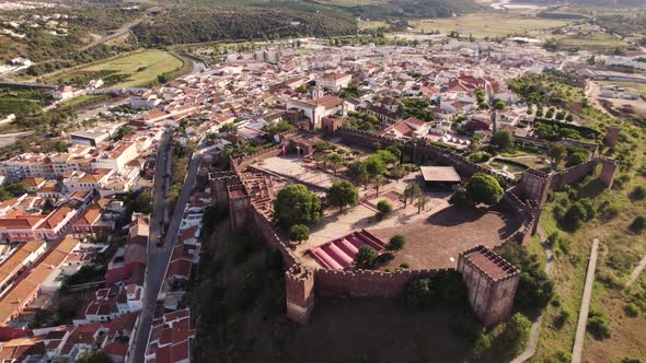 Fortified red sandstone walled city and Castle of Silves, Algarve, Portugal. Orbiting shot alt