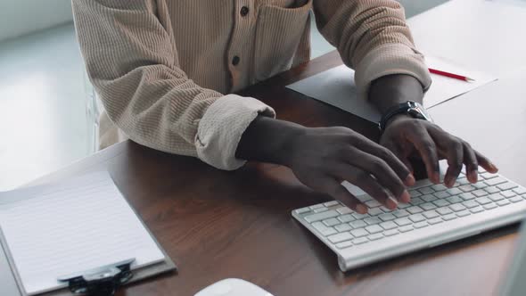 Young Afro-American Businessman Working on Computer and Taking Notes alt