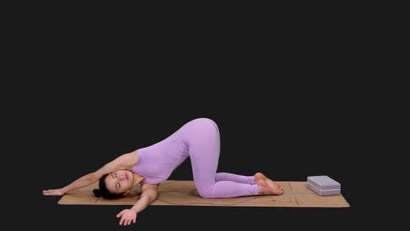 Young Sporty Woman Doing Twisted Puppy Pose while Practicing Yoga, Alpha in alt