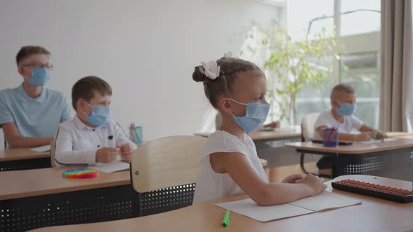 Children at School Sit in the Classroom and Raise Their Hands Answering the Teacher's Questions in alt
