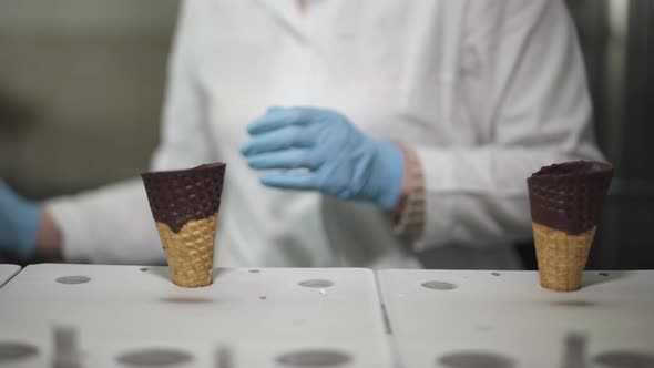 Ice Cream Production, the Worker Distributes Waffle-cones for Ice Cream on the Production Line alt