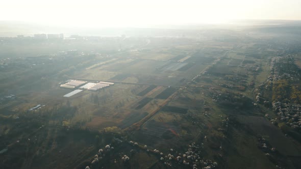 Aerial View of Agricultural Fields Near the City Suburb in the Morning at Sunrise alt