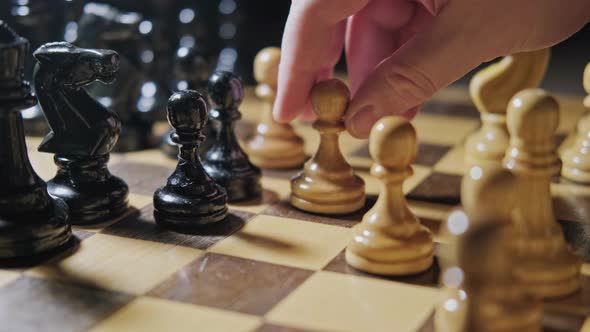 Taking a pawn by a pawn in a chess game. Man hand with a chess piece in a board game