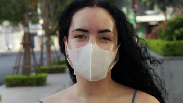 Closeup of an Adult Woman Wearing a Medical Mask Looking Around and Looking at the Camera on an alt