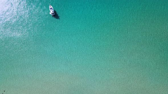 Calm and peaceful macro shot of the turquoise sea shore during daytime alt