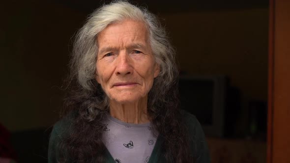 Portrait of an Expressive Old Woman Outdoor Near Her House alt