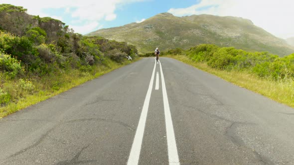 Female cyclist cycling on a countryside road 4k alt