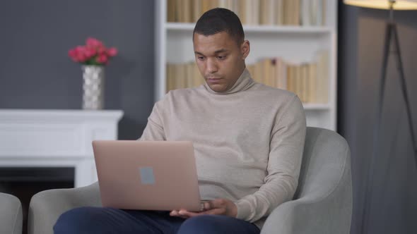 Successful Young African American Man Closing Laptop and Leaving Home Office alt