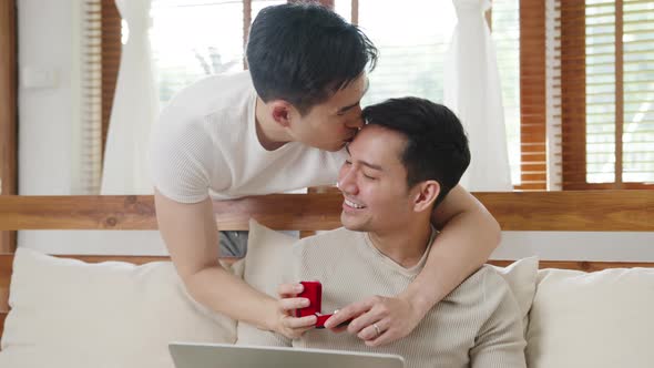 Asia gay couple propose at modern home, LGBTQ men happy smiling have romantic time.