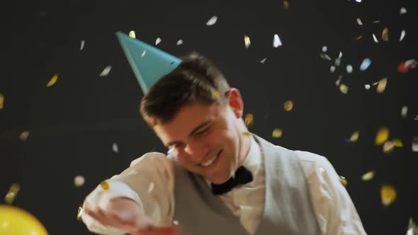 Young man dancing in party hat alt