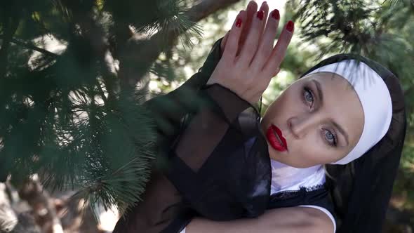 Sinful Woman is Dressed Like Catholic Nun Bright Makeup with Red Lips Posing at Nature Flirting with alt
