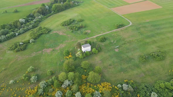 aerial view of a small building in the middle of the green meadows of the hesse area in germany alt