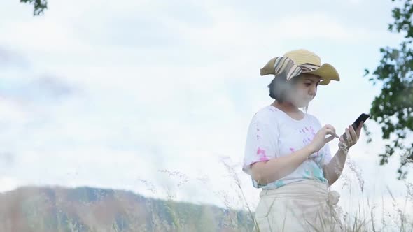 Selfie smartphone with landscape nature white and pink grass flowers on mountain background alt