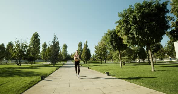 Active Fitness Woman Runner Jogging in Sunny Street Summer Day Outdoors