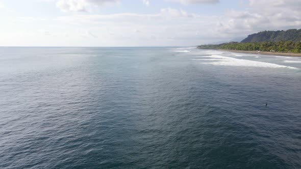 Aerial view of small waves in the ocean in Dominical Beach in Costa Rica, Static Wide shot alt