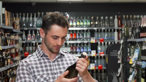 Young Man Smiling To the Camera While Choosing Wine alt
