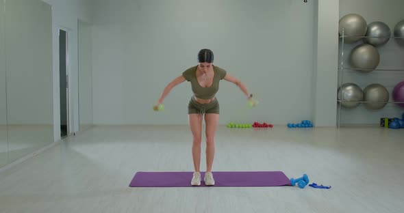 Sports Girl Performs Dumbbell Swings to the Side