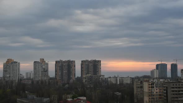 Urban Skyline Time Lapse with Highrise Building Tops and Overcast Sky with Sun Beams Breaking