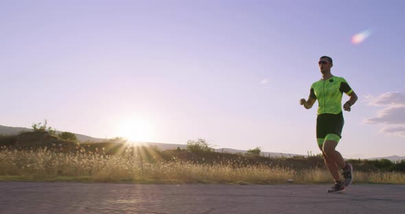 Triathlon  Male Triathlete Running in Triathlon Suit Training for Ironman Race alt