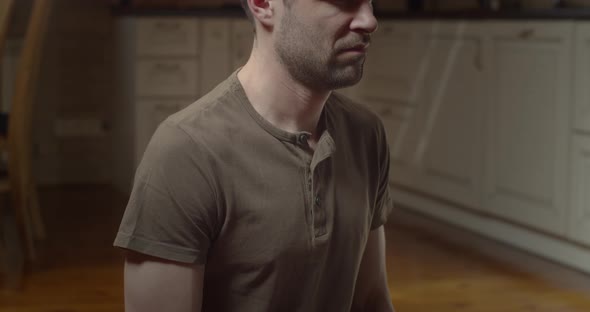 Concentrated Caucasian Yogi Sits in Asana Doing Pranayama Indoors Home Background alt