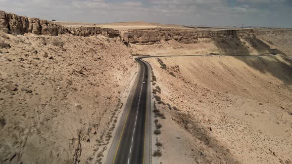 Car Driving on Road Through the Desert the Camera Flies Over the Land the Landscape in Israel