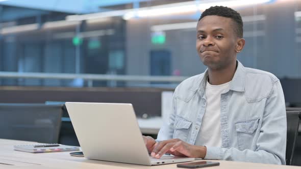 No Gesture with Head Shake by African Man at Work alt