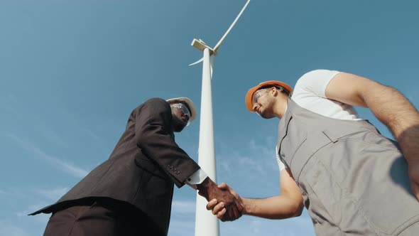 African American Inspector in White Helmet and Black Suit Shaking Hands with alt