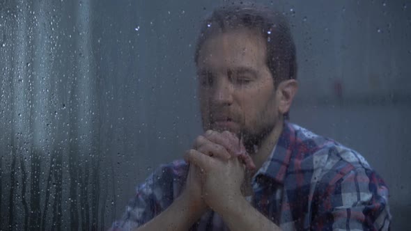 Hopeless Male Praying God Behind Rainy Window Asking for Help and Forgiveness alt