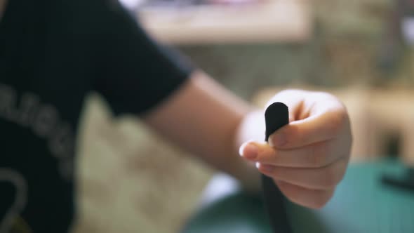 Skilled Designer Cuts Black Leather Strip Edges Closeup alt