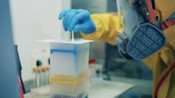 Male Scientist Uses a Q-tip While Working with Coronavirus Vaccine in Laboratory. alt