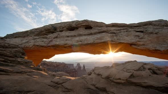 Time lapse of Mesa Arch glowing as the sun shines over the desert alt