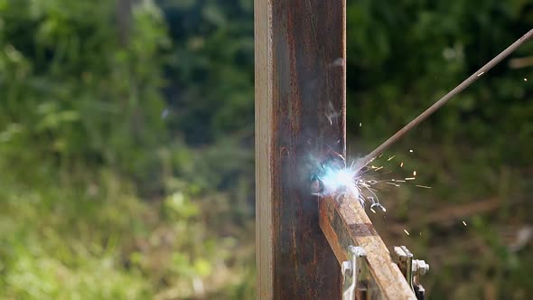 Close View Plank Connected to Pole with Welding Machine alt