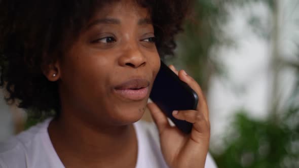 Closeup Face of Smiling Mixed Race Young Woman Having Pleasant Conversation on Smartphone on Blurred alt
