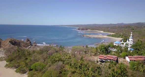 Aerial drone view of the beach, rocks and tide pools in Guiones, Nosara, Costa Rica. alt