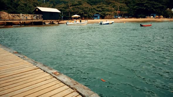 Modern boats arriving on a nordic city very similar to the cities from the vikings tv series. A cold alt