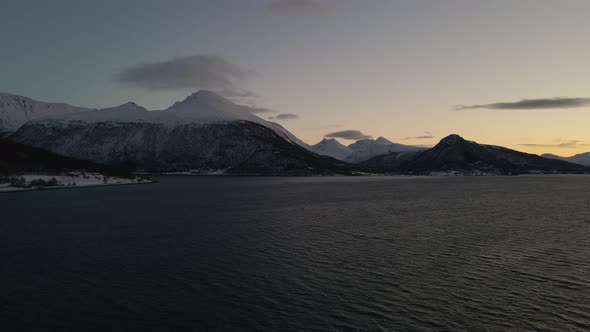 Epic drone view at blue hour of snowy mountain landscape in the Arctic alt
