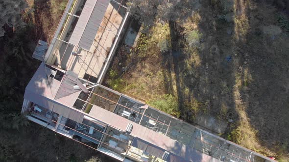 aerial birds eye view of an old abandoned building in an overgrown forest alt