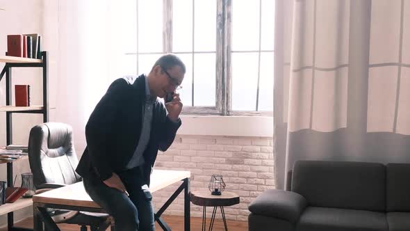 Young Successful Businessman Has a Phone Call in the Office or at Home alt