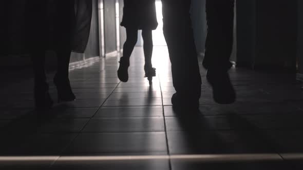 Silhouettes of Girl Riding Scooter and Parents Walking along Hallway 