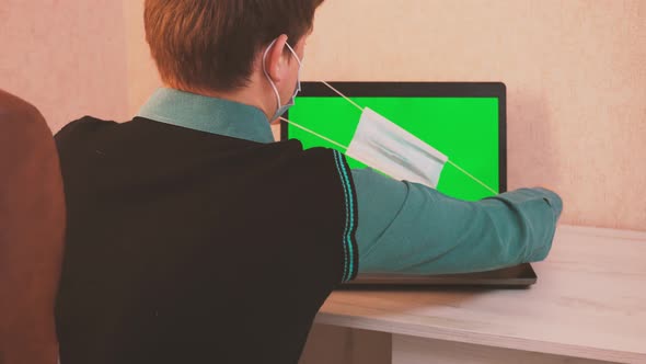 A Man Puts on a Protective Face Mask Himself and on the Interlocutor By Video Call and Starts Typing alt