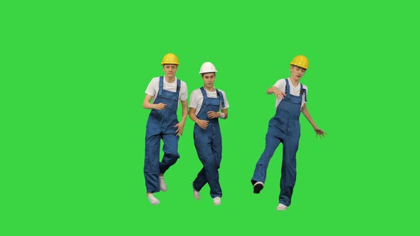 Three Male Construction Workers in Hard Hats Hoping Into the Camera Spot Break Dancing and Jumping alt