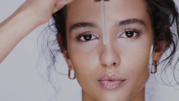 Pretty Girl Showing Pipette with Serum To the Camera and Feeling Surprised alt